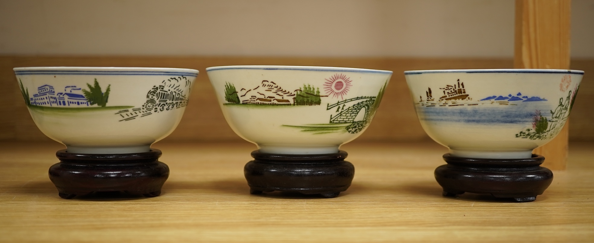 A Chinese Cultural Revolution porcelain teapot, six bowls, wood stands and an enamel tray-29.5cm diameter. (8)